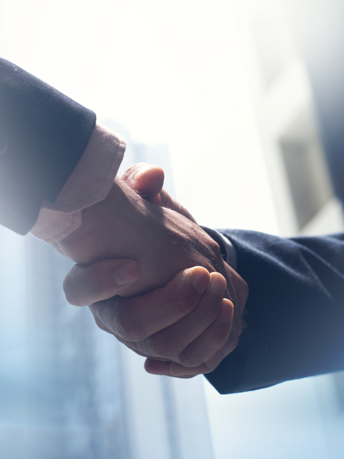 Two people shaking hands, representing business agreements in the prescription drug supply chain
